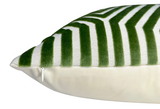 Close-up of a rectangular pillow with a white background and green velvet stripes forming a chevron pattern, featuring a visible white zipper on the side.