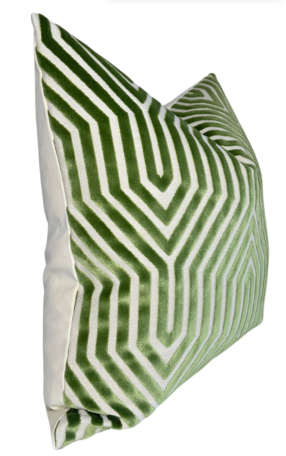 Square pillow with a lettuce green and white geometric maze-like pattern on the front and solid off-white fabric on the back and sides, angled view.
