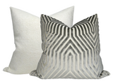 Two square pillows with knife edges; front pillow has a grey and white geometric chevron pattern, the back pillow is solid pale grey with a textured weave.