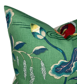 Close-up of lotus flower pillow cover in jade green fabric with blue, yellow, and white floral patterns and delicate line details