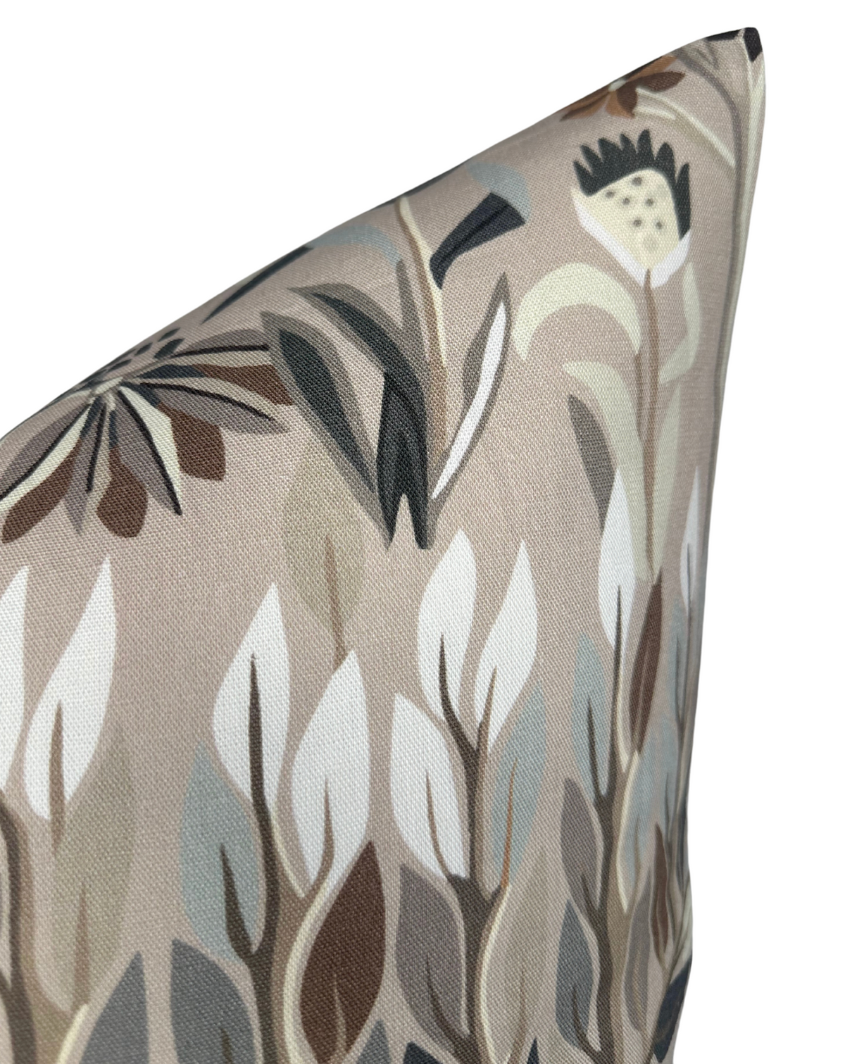 Close-up of a pillow corner featuring a beige background with abstract botanical print in muted shades of brown, white, gray, and black.