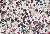 Velvet pillow cover with an abstract pattern of small, scattered floral shapes in pink, grey, black, and white tones, creating a watercolor effect.