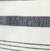 Close-up of a woven textile pillow cover featuring a wide dark gray stripe and two sets of finer parallel dark gray lines on a natural off-white background.