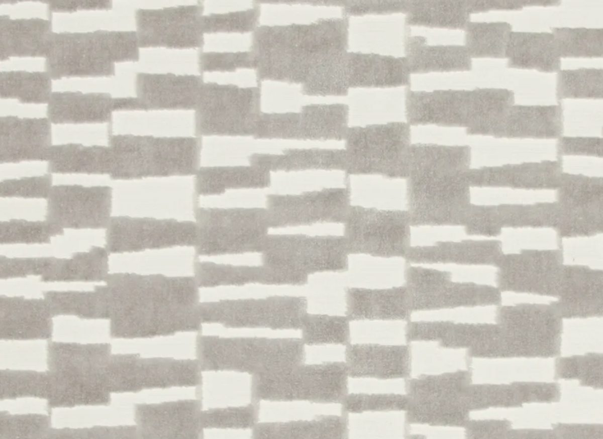 Grey and off-white rectangular blocks arranged in a staggered, abstract plaid pattern on textured fabric.