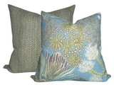 Two square pillows with one featuring a spa blue background and botanical floral design paired with a green pillow covered in a small white dot pattern.