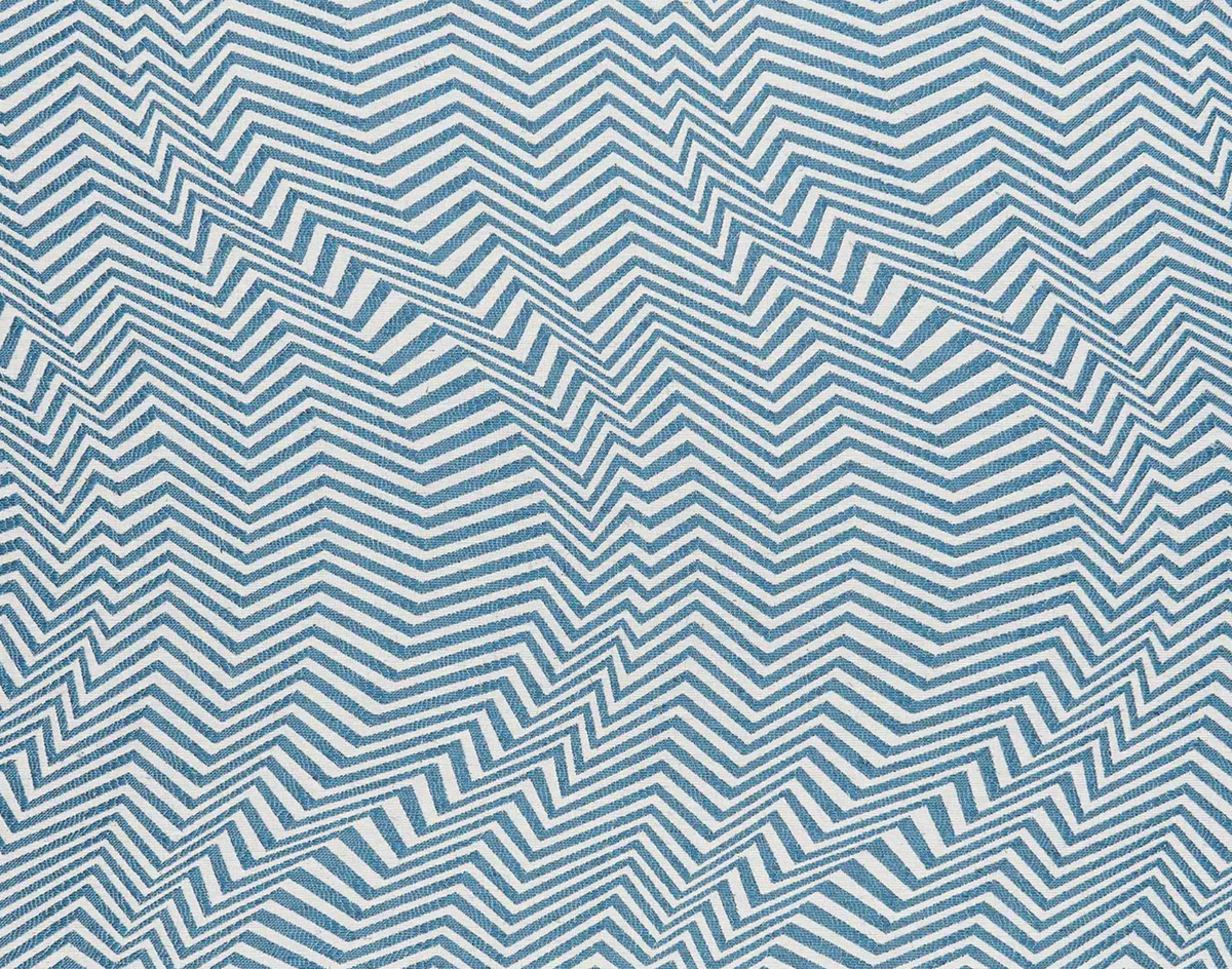 Textile pattern with overlapping zigzag chevrons in varying shades of blue on a light background, creating a dynamic geometric wave effect.