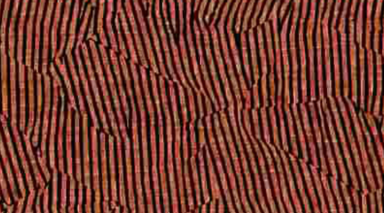 Close-up of salmon-colored Avant pillow cover with irregular black and brown vertical stripe pattern forming abstract shapes.