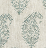 Close-up of a fabric with a celadon paisley print featuring intricate floral motifs on a natural beige linen-textured background.