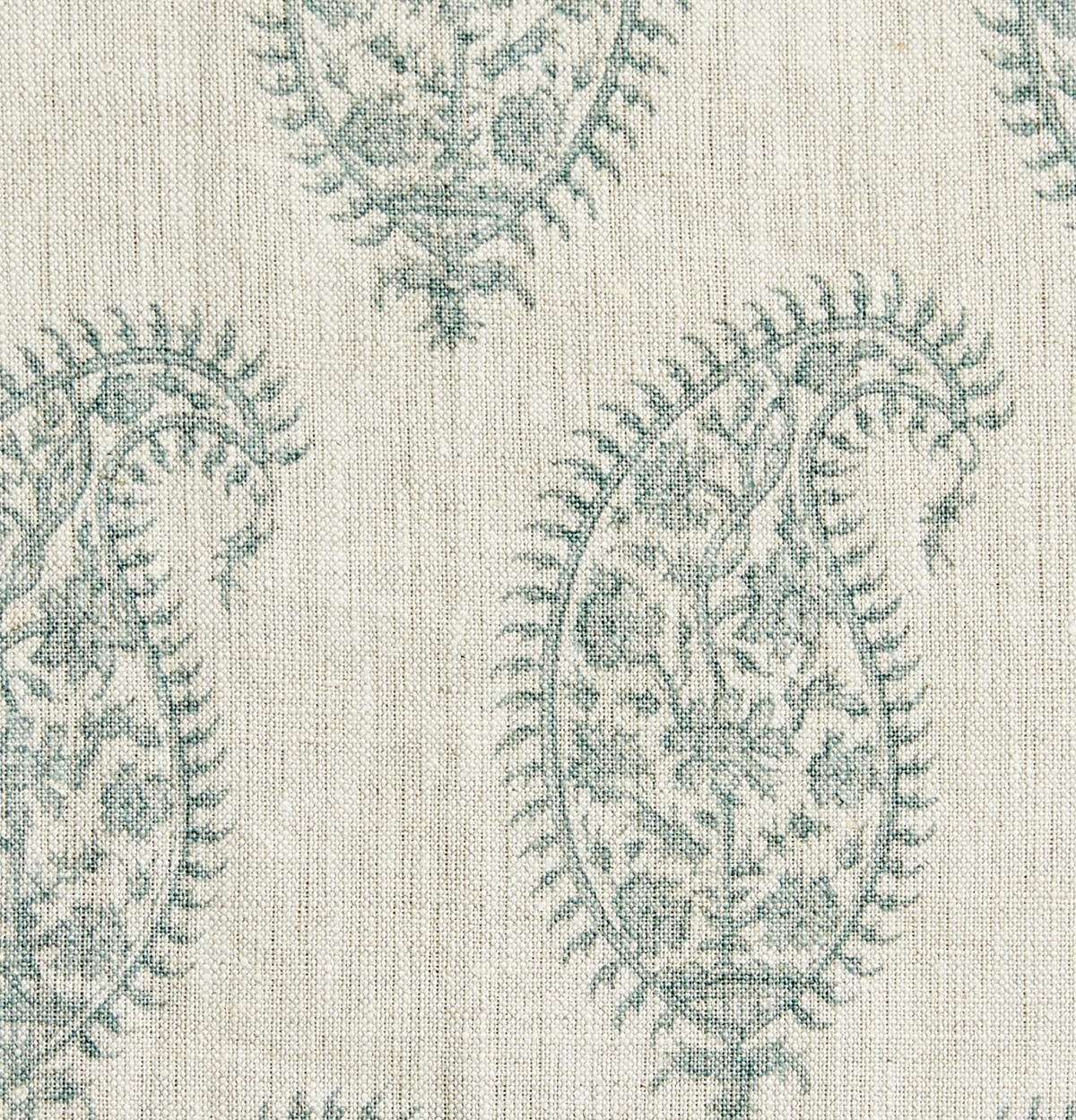 Close-up of a fabric with a celadon paisley print featuring intricate floral motifs on a natural beige linen-textured background.