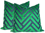 Two square dark blue velvet pillow covers with an emerald green cut velvet geometric chevron pattern, shown slightly overlapping on a white background.