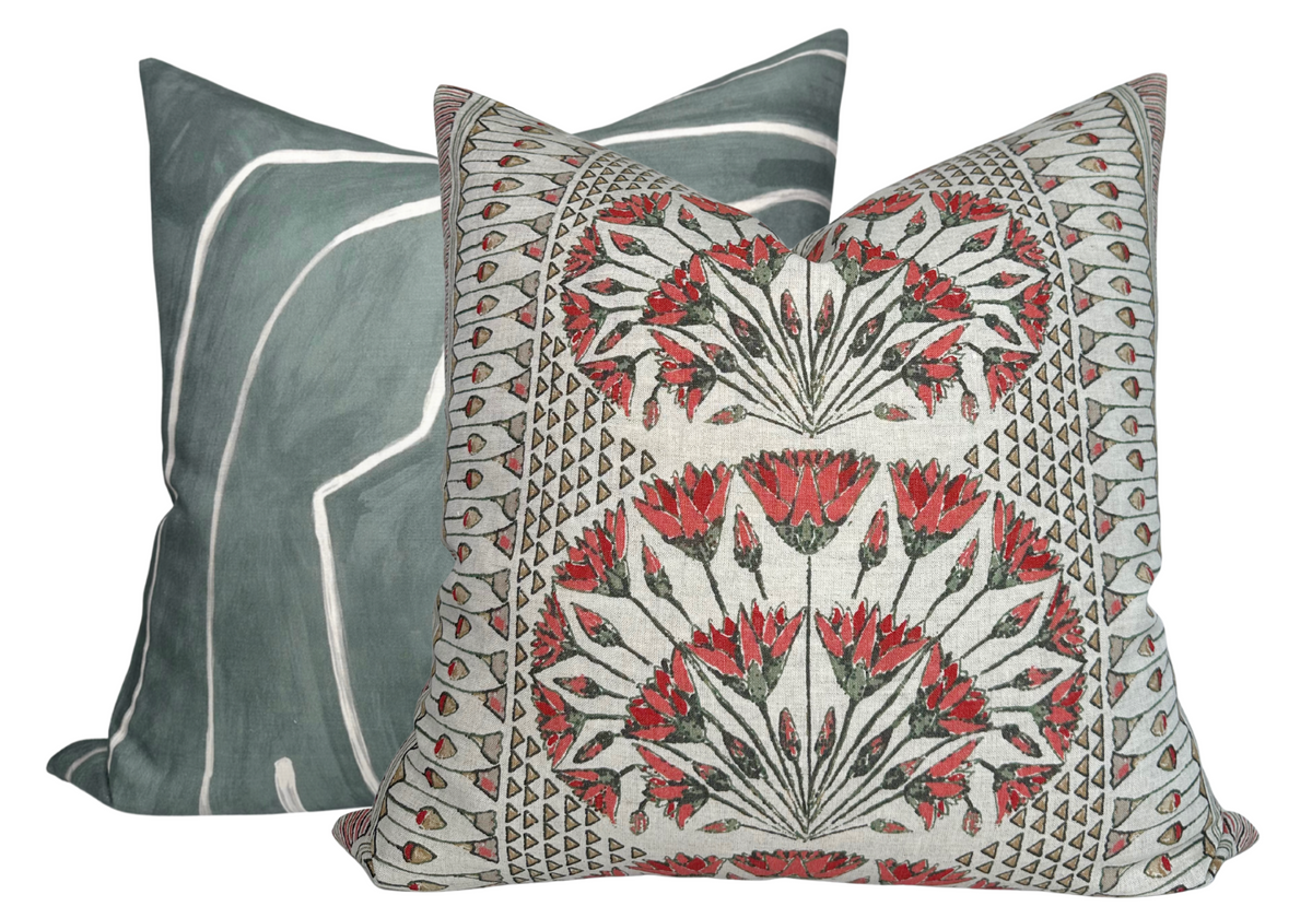 Square pillow with intricate coral and gray floral pattern in front of square pillow with abstract gray and white design.