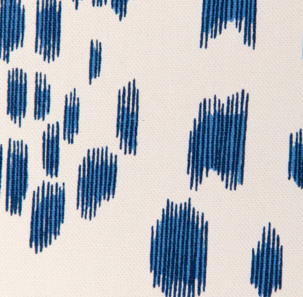 Close-up of blue irregular vertical dash patterns on off-white fabric, showing textured weave of the Les Touches Pillow Cover in Blue.