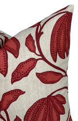 Close-up of pillow corner with large sunbaked red floral and dotted leaf pattern on a beige background fabric.