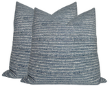 Three square pillows with horizontal striped patterns in varying shades of blue and white, arranged together showing textured fabric detail.