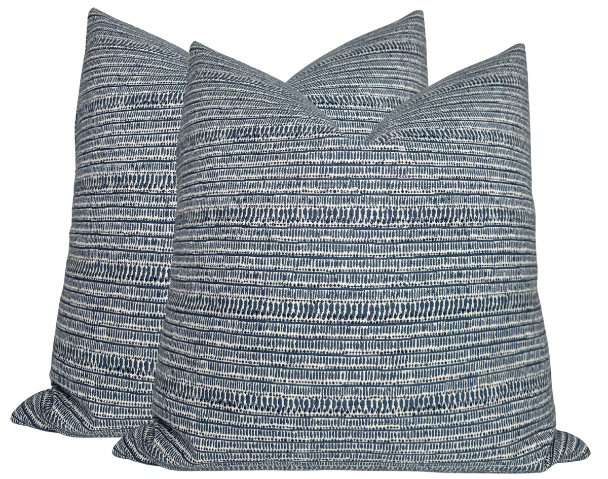 Three square pillows with horizontal striped patterns in varying shades of blue and white, arranged together showing textured fabric detail.