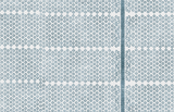 Blue and white textile with repeating small floral motifs and a vertical leafy vine pattern on the right side, showing intricate weaving details.