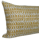 Rectangular saffron-colored pillow cover with horizontal rows of white, stylized leaf patterns detailed with tiny black dots, shown from a slight side angle.