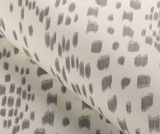 Close-up of Les Touches pillow cover in gray featuring an abstract pattern of short vertical and horizontal brushstroke clusters on a light background.