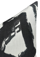 Close-up of a pillow cover featuring bold black brushstroke patterns on a white fabric background, showing texture and sharp contrast.