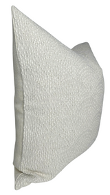 Rectangular natural-colored woven pillow cover featuring a subtle inverse scalloped textured pattern, shown angled against a white background.