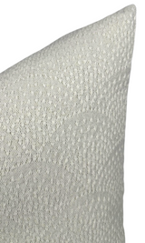Close-up of a natural-colored woven pillow cover featuring an inverse scalloped texture with raised diamond patterns in soft off-white tones.