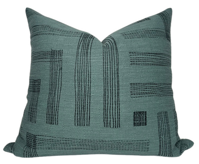 Pastiche Pillow Cover in Spruce Jet color displayed on a sofa setting