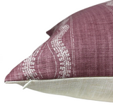 Close-up of a Zanzibar Pillow Cover with a textured maroon fabric featuring white intricate border patterns and a beige reverse side with visible zipper.