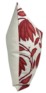 Square pillow with a neutral beige fabric on the back and sides, and a sunbaked red floral pattern with stylized leaves on a white front panel.
