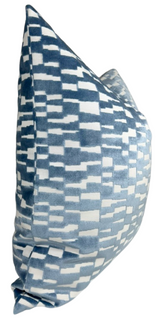 Square pillow with a geometric pattern of irregular horizontal blue and white rectangles, creating a pixelated effect on soft fabric.