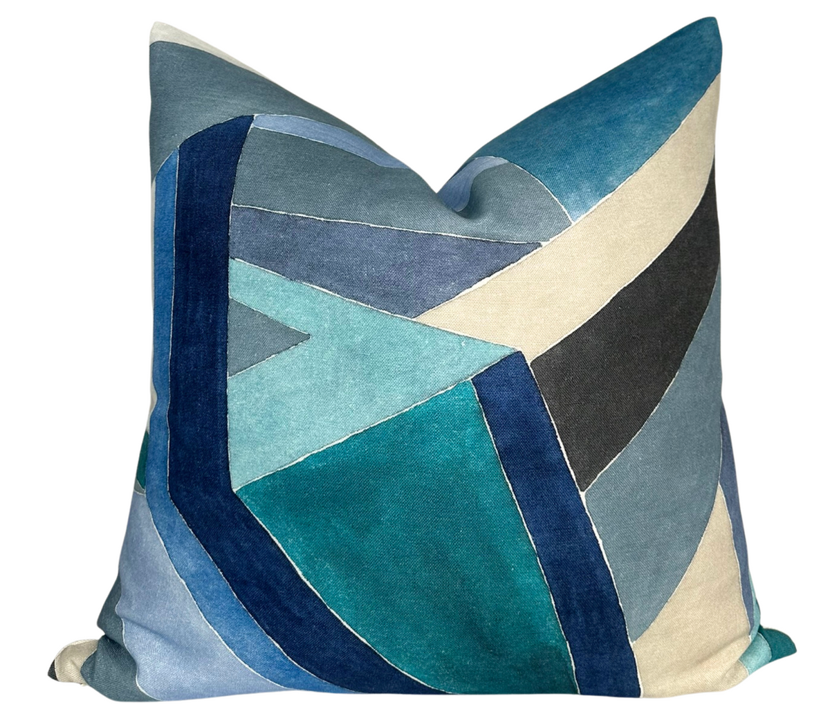 Square pillow cover with an angular geometric pattern in shades of navy, teal, gray, cream, and black velvet textures.