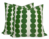 Two square pillow covers with a repeating vertical pattern of connected green circular shapes on a white background.