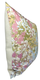 Square linen pillow cover with a blush floral pattern featuring pink, white, and blue flowers and green foliage on one side and solid beige on the back.