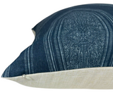 Close-up of a pillow featuring an indigo blue cover with intricate embroidered circular patterns and a natural beige fabric on its side.