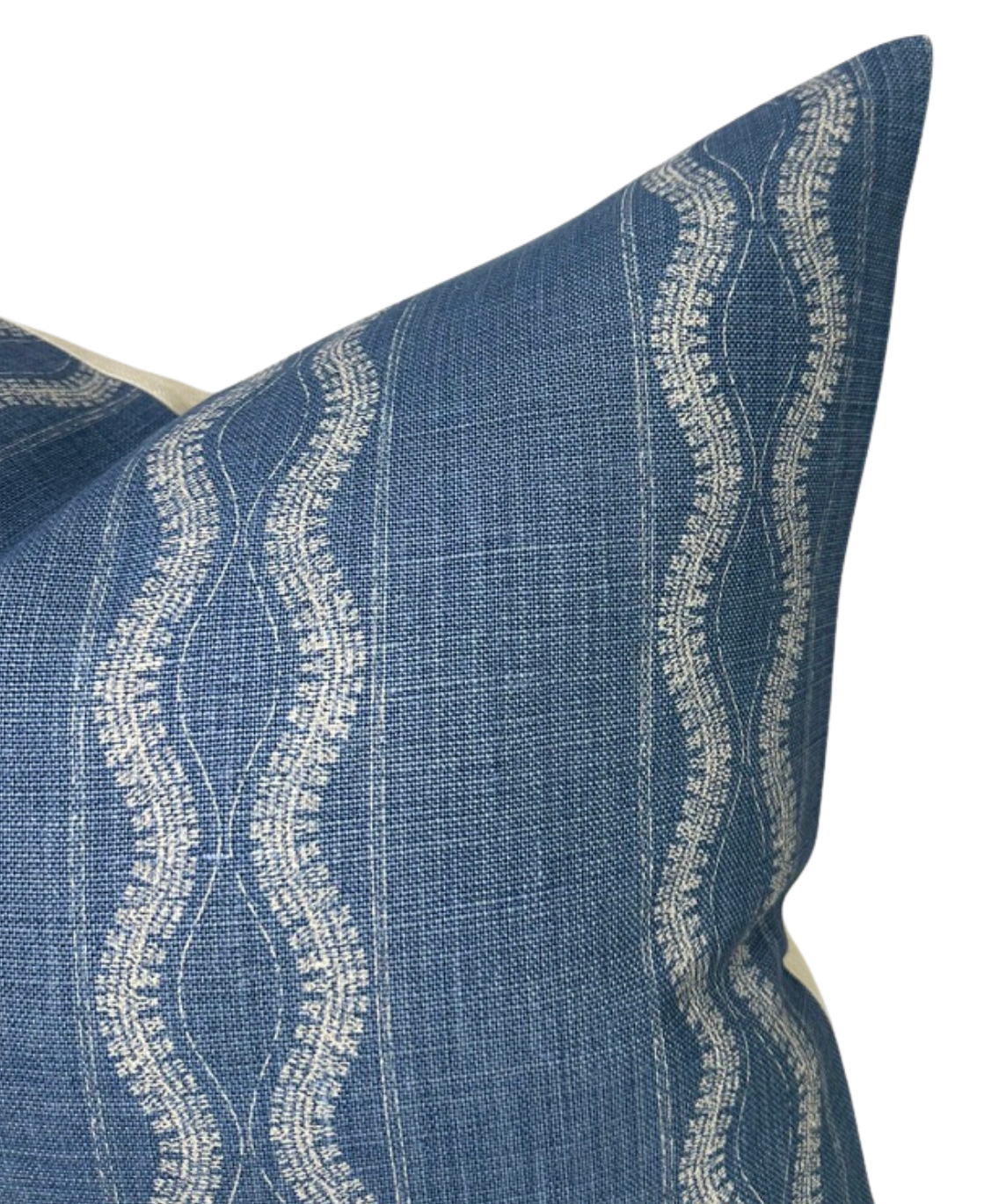Close-up of an indigo blue pillow cover featuring vertical wavy white embroidered lines on a textured woven fabric background.