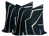 Three black pillow covers with beige irregular linear patterns arranged closely together against a white background.