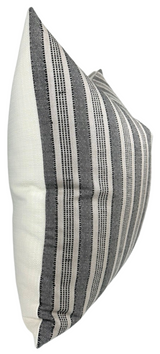 Rectangular pillow with vertical black and charcoal textured stripes on a natural cream background, shown at a side angle highlighting its plush shape.