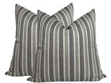 Two square pillow covers with vertical charcoal and natural striped pattern, textured woven fabric by Peter Dunham Textiles.