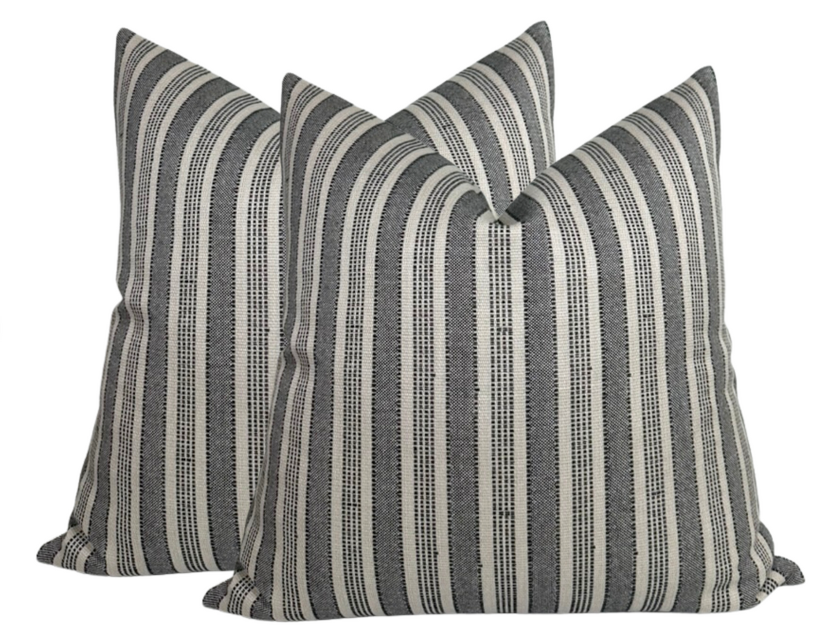 Two square pillow covers with vertical charcoal and natural striped pattern, textured woven fabric by Peter Dunham Textiles.