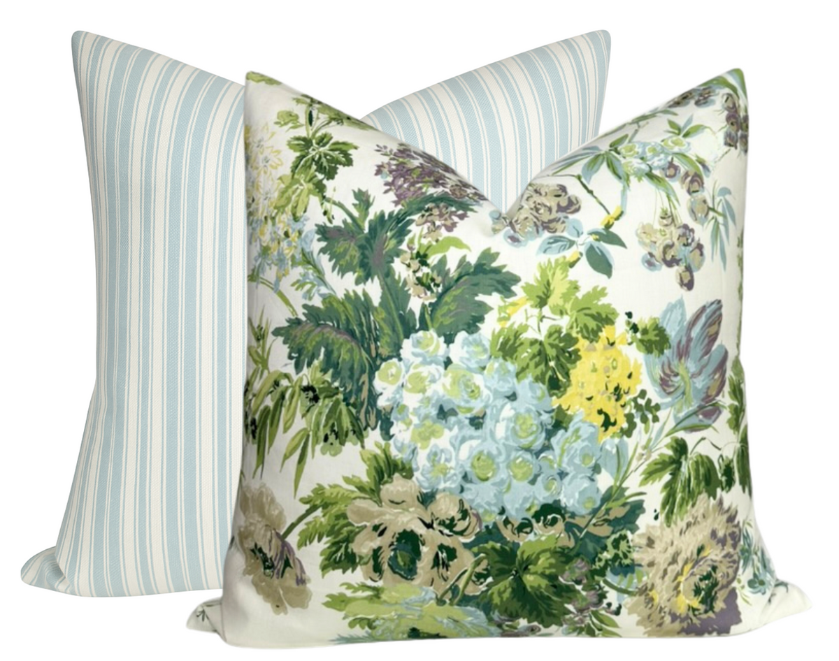 Square pillow covers featuring a front floral pattern with green, blue, yellow, and purple blooms and a back cover with soft blue and white vertical stripes.
