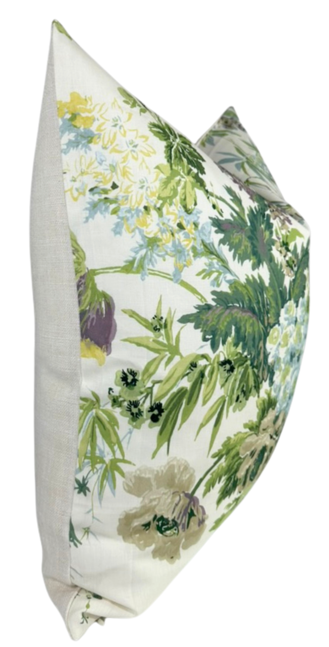 Rectangular pillow cover with a multicolored botanical pattern featuring green leaves and white, yellow, and purple flowers on a light background.