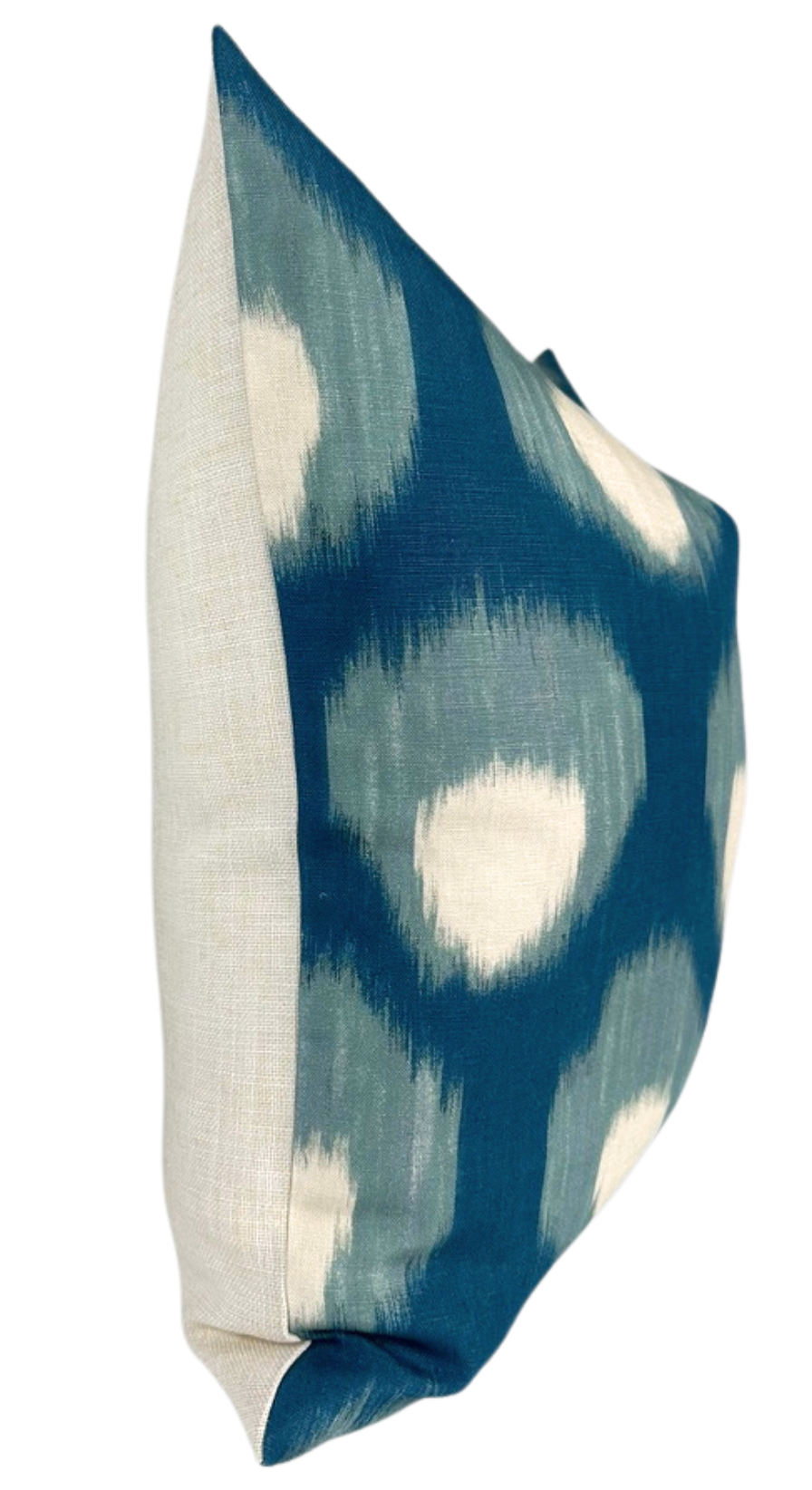 Square pillow with a blue and white blurred circular pattern on the front and solid natural-colored fabric on the sides, shown at an angle.