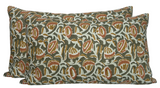 Rectangular pillow covers with an intricate pattern of rust and olive shapes on a light beige background, featuring a piped edge detail.