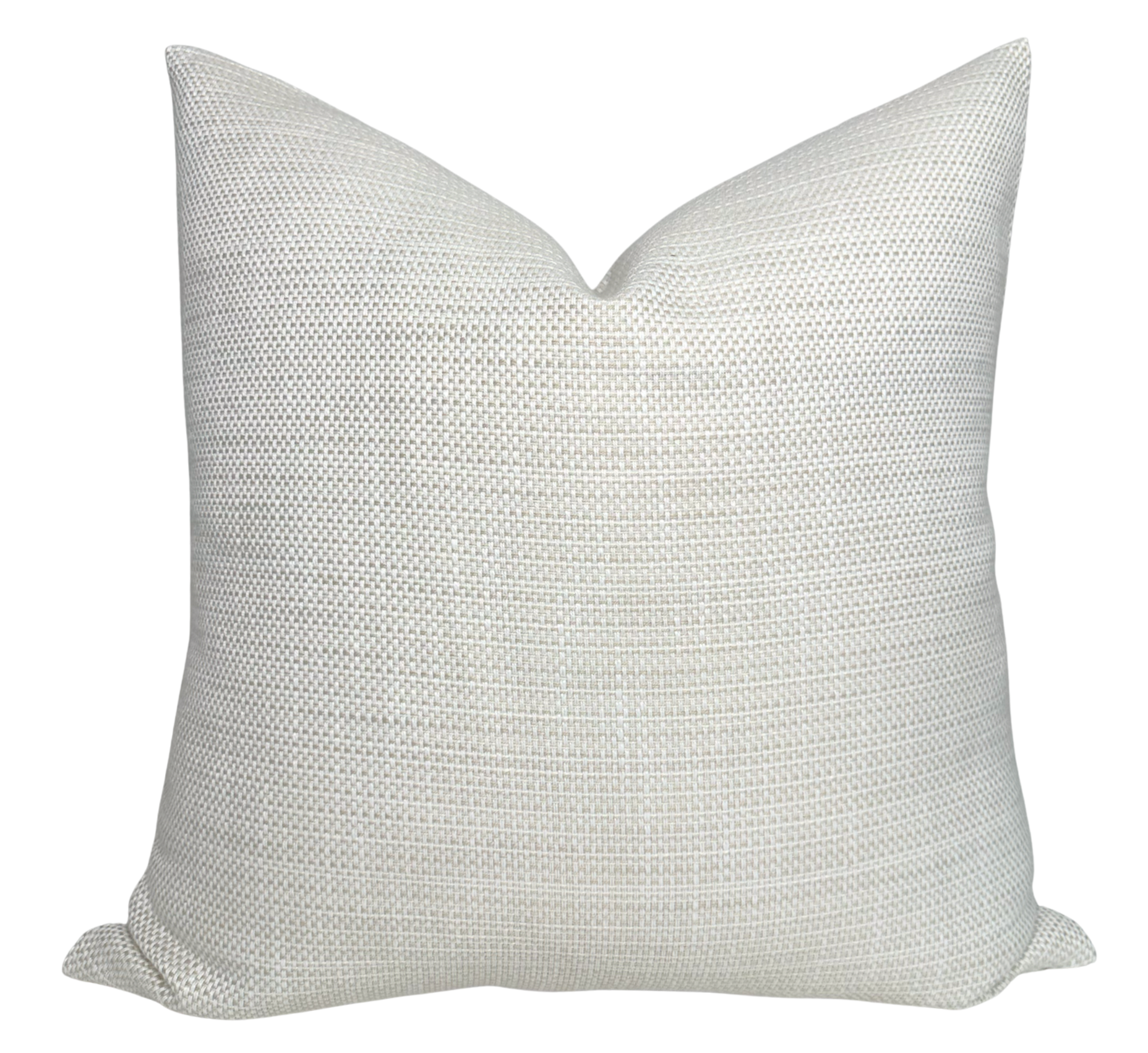 Kravet Woven Pillow Cover in Tan displayed on a wooden surface with a cozy interior backdrop