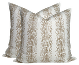 Pair of square pillow covers with vertical dotted stripe pattern in fawn brown on off-white background, arranged side by side at an angle.