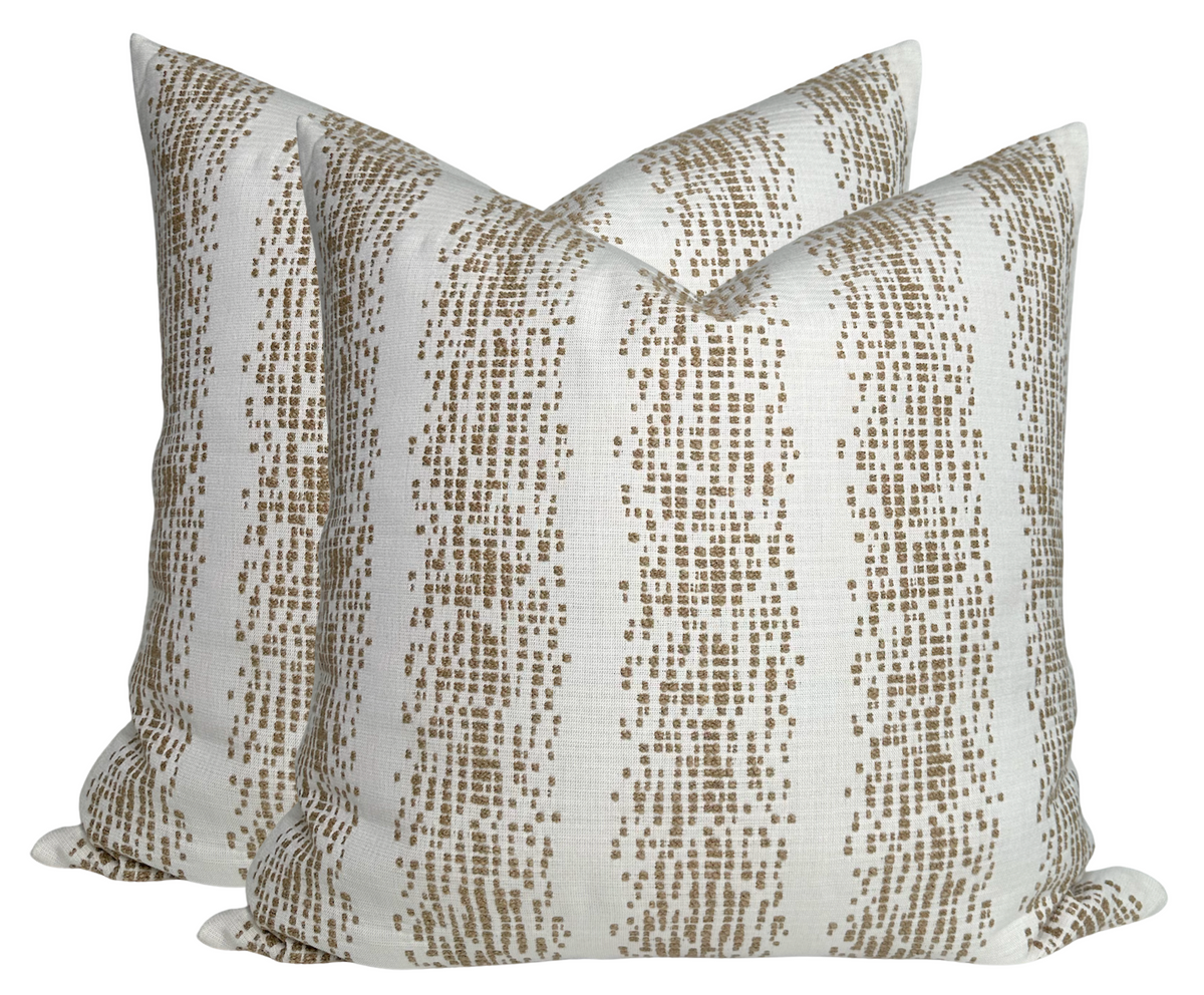 Pair of square pillow covers with vertical dotted stripe pattern in fawn brown on off-white background, arranged side by side at an angle.