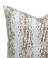 Close-up of a white pillow cover featuring an irregular vertical pattern of small fawn brown rectangles and squares forming organic stripes.