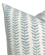 Cream linen pillow cover featuring a repeating vertical pattern of blue willow-inspired floral vines with paired leaves, shown close-up on two overlapping pillows.