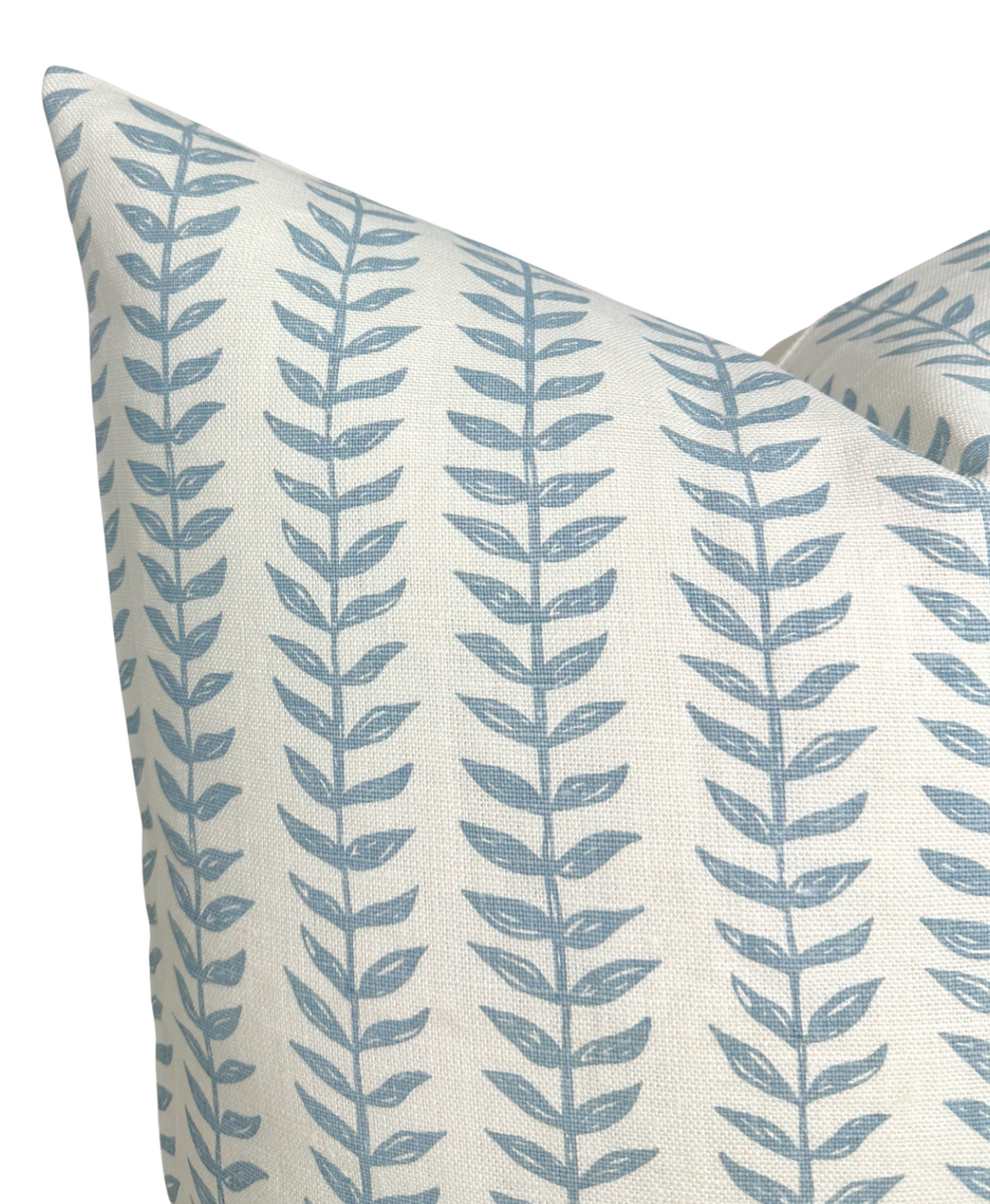 Cream linen pillow cover featuring a repeating vertical pattern of blue willow-inspired floral vines with paired leaves, shown close-up on two overlapping pillows.