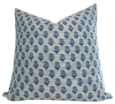 Rajmata woven pillow cover in blue featuring Indigo on Ocean fabric on front and ivory backing, styled on a sofa.