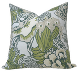 Square pillow cover with a large floral pattern in muted green, gray, and cream colors on a light background, shown angled to display fullness.